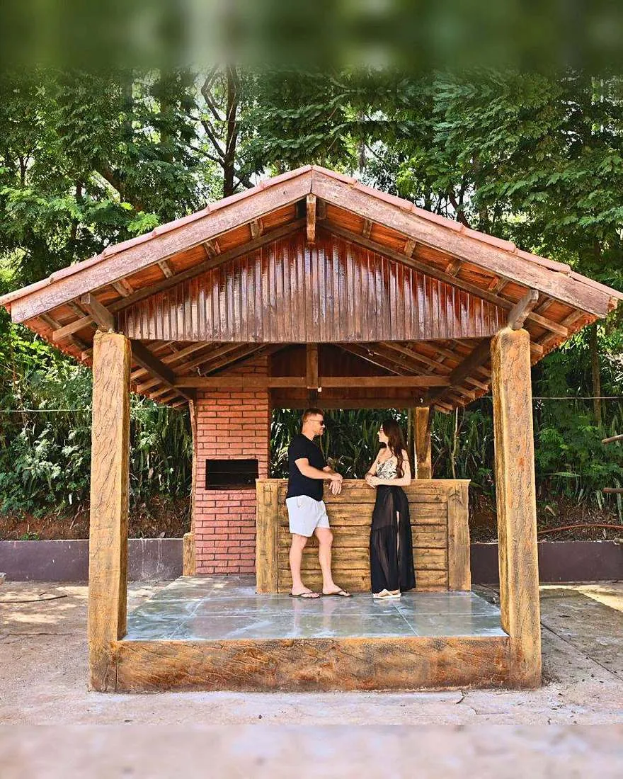 Casal conversando em um quiosque de madeira com churrasqueira de tijolos